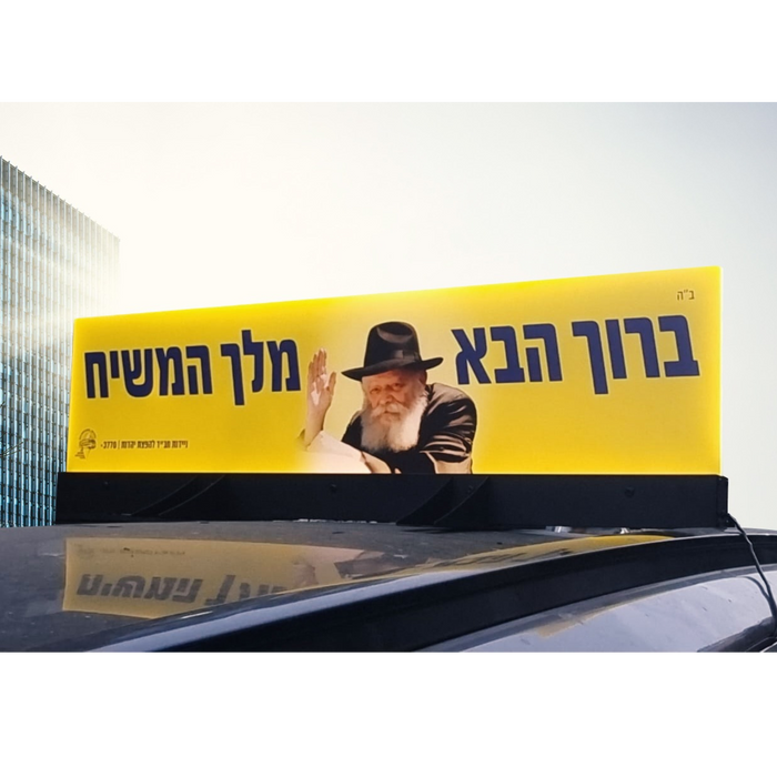 שלט מואר ברוך הבא מלך המשיח עם תמונת הרבי מליובאוויטש מותקן על גג רכב